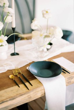 Siyah tabak, şenlikli ahşap bir masanın menüsünün yanında beyaz bir peçetenin üzerinde duruyor. Yüksek kalite fotoğraf