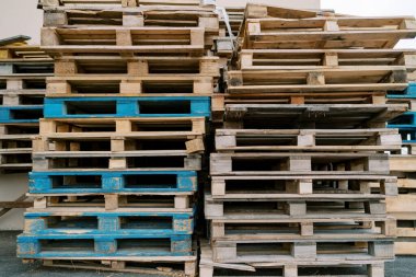 Tahta paletler bir deponun dış duvarının yanında istiflenmiş. Yüksek kalite fotoğraf