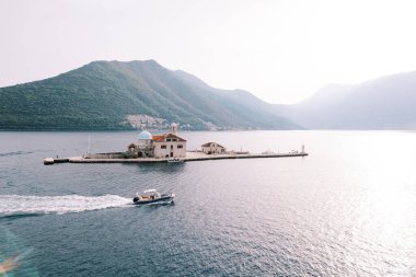 Motorlu tekne Gospa od Skrpjela adasını geçerek deniz boyunca yol alır. Karadağ. Drone. Yüksek kalite fotoğraf