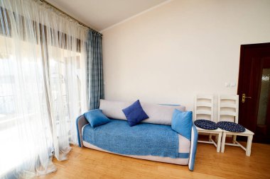 Panoramik pencerenin yanında büyük bir kanepe ve sandalyeli oturma odası. Yüksek kalite fotoğraf