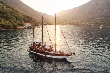 Yelkenlideki turistler güneşin altında dağlık sahil boyunca yelken açarlar. Drone. Yüksek kalite fotoğraf