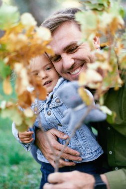 Sararmış meşe dalından bir babanın ve küçük kızının kucaklaşmasını izle. Yüksek kalite fotoğraf
