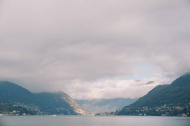 Como Gölü kıyısındaki dağ sırtından sis iniyor. İtalya. Yüksek kalite fotoğraf