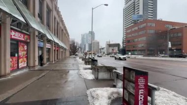 Kış boyunca kar ve modern mimari ile bir şehir caddesinin kaldırım manzarası.