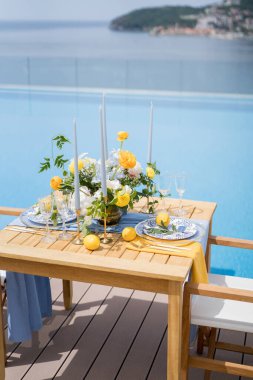 Parlak bir buket çiçekli şenlik masası havuzun yanında duruyor. Yüksek kalite fotoğraf