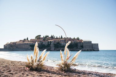 Düğün kemeri Sveti Stefan adasına bakan bir sahilde duruyor. Karadağ. Yüksek kalite fotoğraf