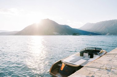 Motorlu yat, dağ sırasına bakan sahile demirlemiş. Yüksek kalite fotoğraf