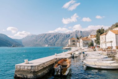 Beyaz balıkçı tekneleri bir taş iskeleye demirlemiş. Perast, Karadağ. Yüksek kalite fotoğraf