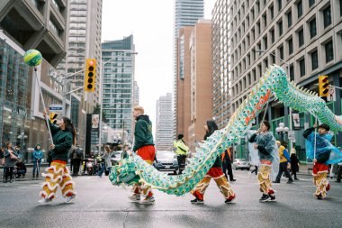 Enerji dolu hareketli bir şehir caddesinde canlı bir ejderha dansı gösterisi gerçekleşiyor.