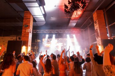 Konuklar bir restoranda sahne kenarında bir müzik grubuyla dans ediyorlar. Yüksek kalite fotoğraf