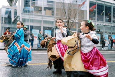 Cocuklar renkli hobi atlarina biniyorlar ve bu geçit töreninde halk ruhu sergiliyorlar.