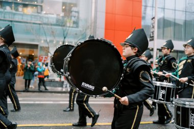 Canlı bir bando, bir şehir geçit töreninde enerjik bir performans sergiliyor.