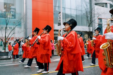 Enerji dolu, parlak kırmızı elbiseli yetenekli müzisyenlerle dolu canlı bir geçit töreni.