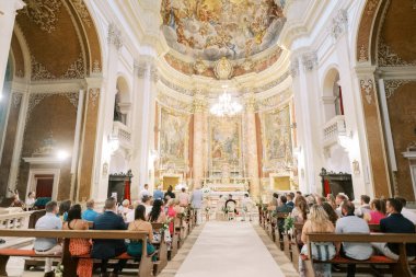 Misafirler kilisedeki bir düğün töreninde banklarda otururlar. Yüksek kalite fotoğraf