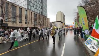 Yürüyüş bandosu yağmurlu bir geçit töreninde, seyirciyi müzikleriyle büyülüyor.