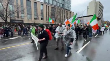 Aziz Patrick Günü 'nü kutlayanlar, bayrak sallayıp yağmurluk giyiyorlar.