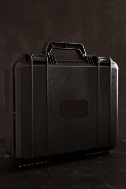 Elektronik aletler için sapı olan mühürlü şok geçirmez çanta siyah mermer bir masanın üzerinde duruyor. Yüksek kalite fotoğraf