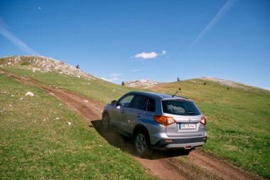 Büyük bir SUV mavi gökyüzüne karşı yokuş yukarı gidiyor. Yüksek kalite fotoğraf