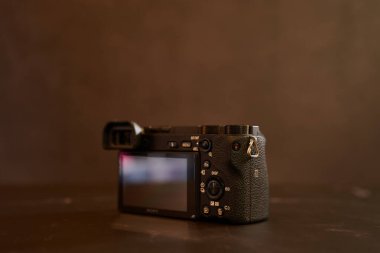 Sony A6000 dijital aynasız kamera siyah mermer bir masanın üzerinde duruyor. Arkadan bak. Yüksek kalite fotoğraf