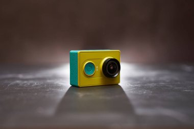 Sarı Xiaomi Y1 aksiyon kamerası siyah bir masada yan duruyor. Yüksek kalite fotoğraf