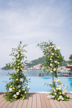 Düğün kemeri, deniz ve dağlara bakan otel havuzunun kıyısında duruyor. Yüksek kalite fotoğraf