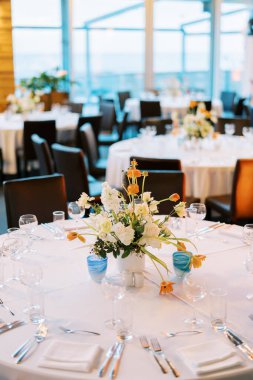 Restoranda bir buket çiçekli yuvarlak bir şenlik masası. Yüksek kalite fotoğraf