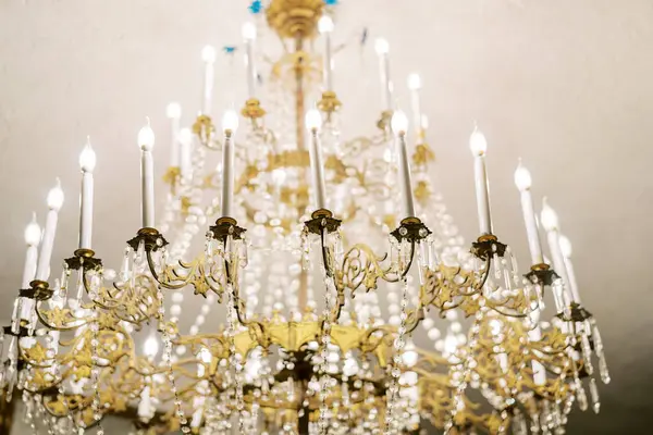 Tavandan sarkan kristal kolyeleri ve mum lambaları olan antika avize. Yüksek kalite fotoğraf