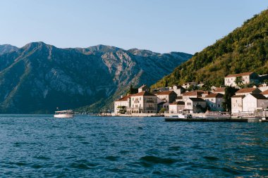Tekneler yeşil dağların eteğinde Perast kıyısı açıklarında denizde yüzerler. Karadağ. Yüksek kalite fotoğraf