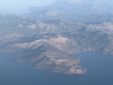 Pencereden deniz kıyısındaki yüksek bir dağ sırasına bak. Yüksek kalite fotoğraf