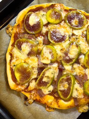 İncirli ve pastırmalı ev yapımı pizza pişirme tepsisinde yatıyor. Yüksek kalite fotoğraf