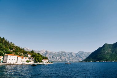 Gemiler Perast açıklarında denize demirlemiş, dağların eteklerindeki antik evlerle. Karadağ. Yüksek kalite fotoğraf