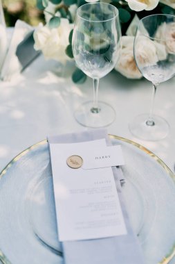 Şahsi davetiye masanın üzerindeki şenlikli menüye iliştirilmiştir. Yüksek kalite fotoğraf
