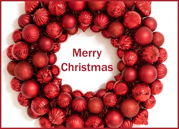 Merry Christmas holiday greeting card or background with green Happy Holidays text.  Red Wreath made of red christmas ornaments.