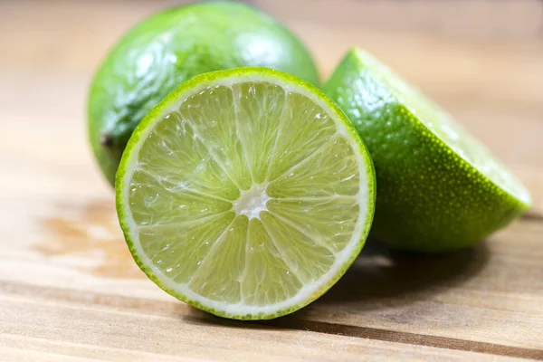 Három Friss Gyümölcsös Lime Csoport Vágódeszkán Stock Kép