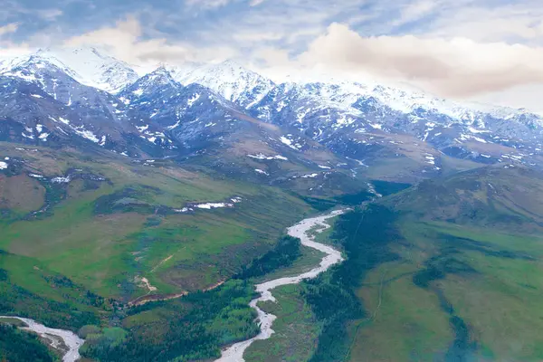 阿拉斯加山脉和流经偏远山谷的河流的空中景观 图库照片