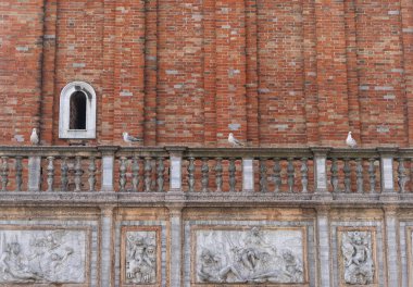 Tuğla heykeli, tarihi taş sanat eserleri ve Venedik, İtalya 'da bir binanın yan tarafında dört martı.