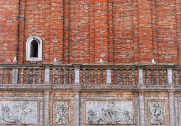 Tuğla heykeli, tarihi taş sanat eserleri ve Venedik, İtalya 'da bir binanın yan tarafında dört martı.