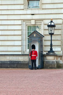Londra, İngiltere, İngiltere - 1 Mayıs 2025: İngiliz Kraliyet Muhafızları, Londra 'daki Buckingham Sarayı' nın girişindeki görevinde..
