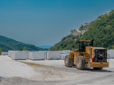 CARRARA, ITALY - JUNE 17, 2023: Large blocks of marble partly cut out of the Apuan Alps in one of the quarries near Carrara, Italy clipart
