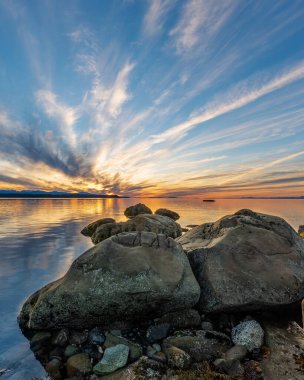 Phipps Point, Hornby Adası, British Columbia, Kanada 'daki kayaların ardında güzel bir günbatımı.