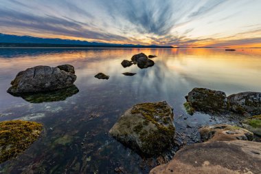 Hornby Adası, British Columbia, Kanada açıklarında kayalar ve denizle güzel bir gün batımı.