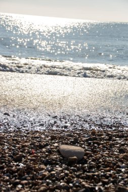 Kum ve işportacıların soğuk ve buzlu okyanus suyu ve plajla buluştuğu bir manzara.