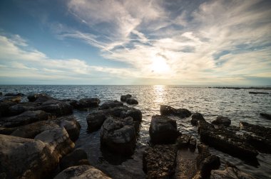 Istrian yarımadasının kıyısında. Hırvatistan 'da deniz ve kayalar. Adriyatik Denizi kıyısında gün batımında. Sahilde taş plajı 