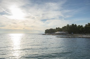 Umag şehrindeki Istrian yarımadasının kıyısında. Hırvatistan 'da deniz ve kayalar. Adriyatik Denizi kıyısında gün batımında