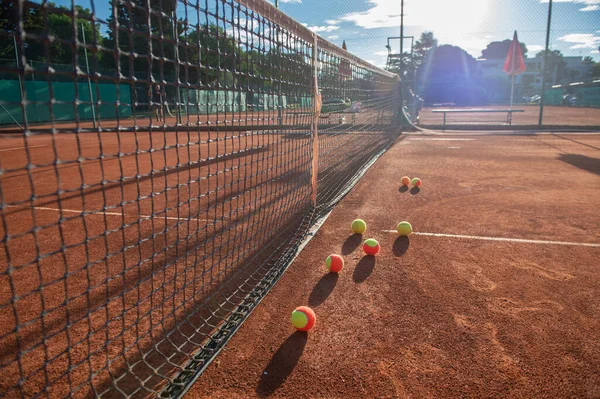 Colorful tennis balls on a clay tennis court