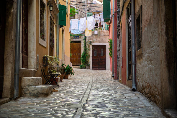 A small cobbled street in a Mediterranean country. Beautiful window shutters. Clear and sunny day. Rovinj, Istrian Peninsula, Croatia