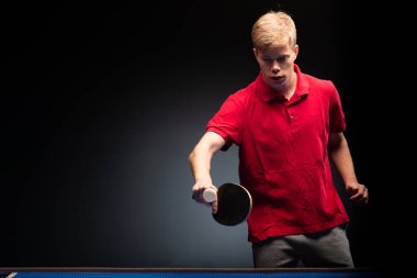 Siyah arka planda tenis oynayan genç adamın portresi