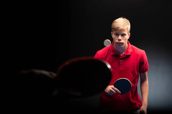 黒を背景にテニスをする若い男の肖像 — ストック写真