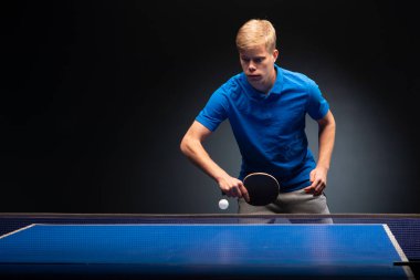 Siyah arka planda tenis oynayan genç adamın portresi