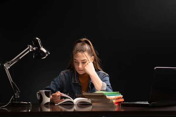 stock image Female student, with books at her desk.  The girl is sitting at the table and study